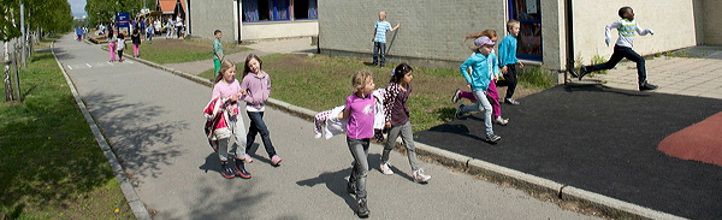 Elever som går forbi skolebygget